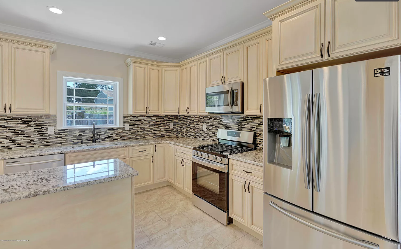 A kitchen with stainless steel appliances and white cabinets.