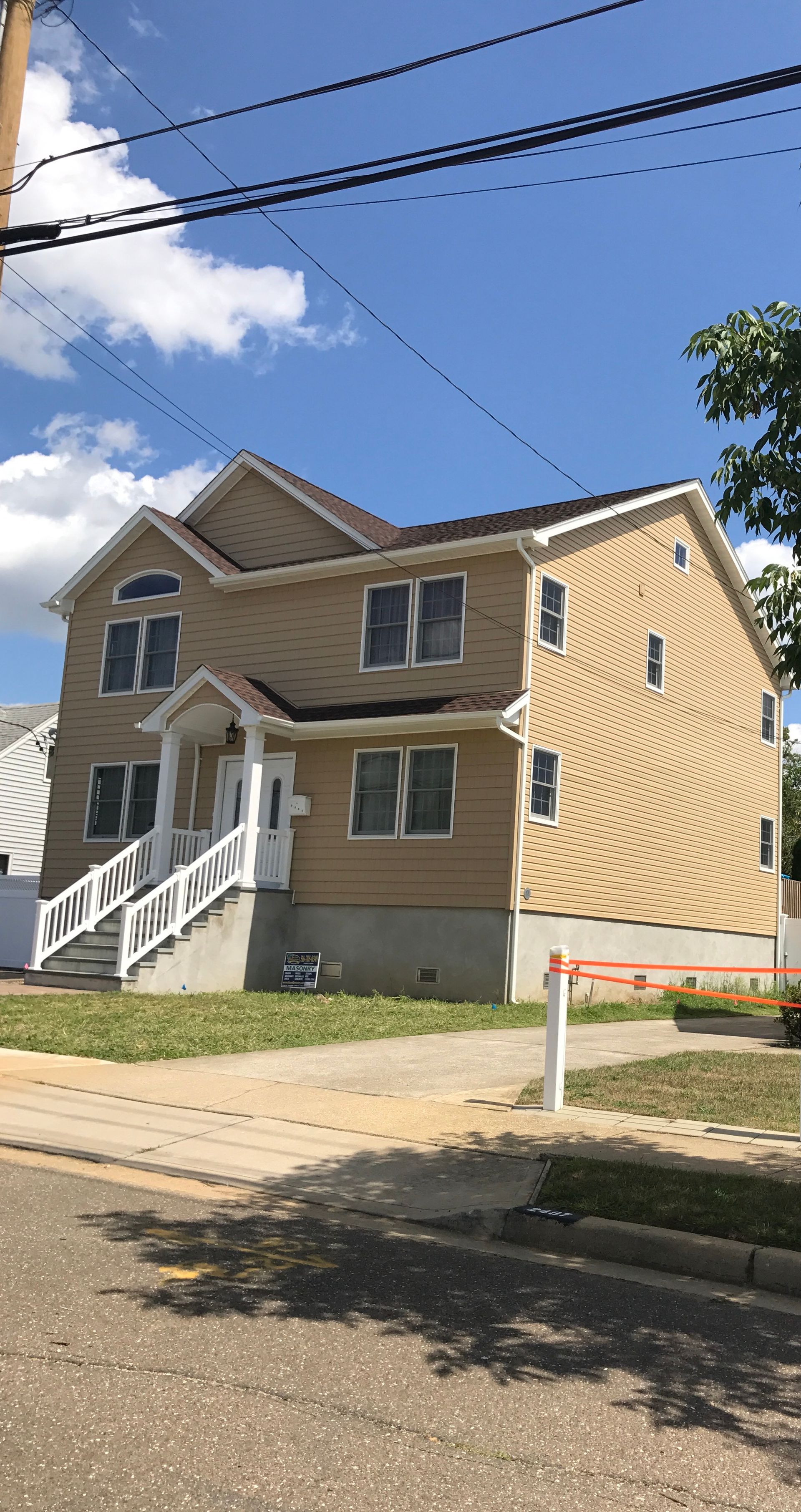 A large house with stairs and a blue sky in the background.