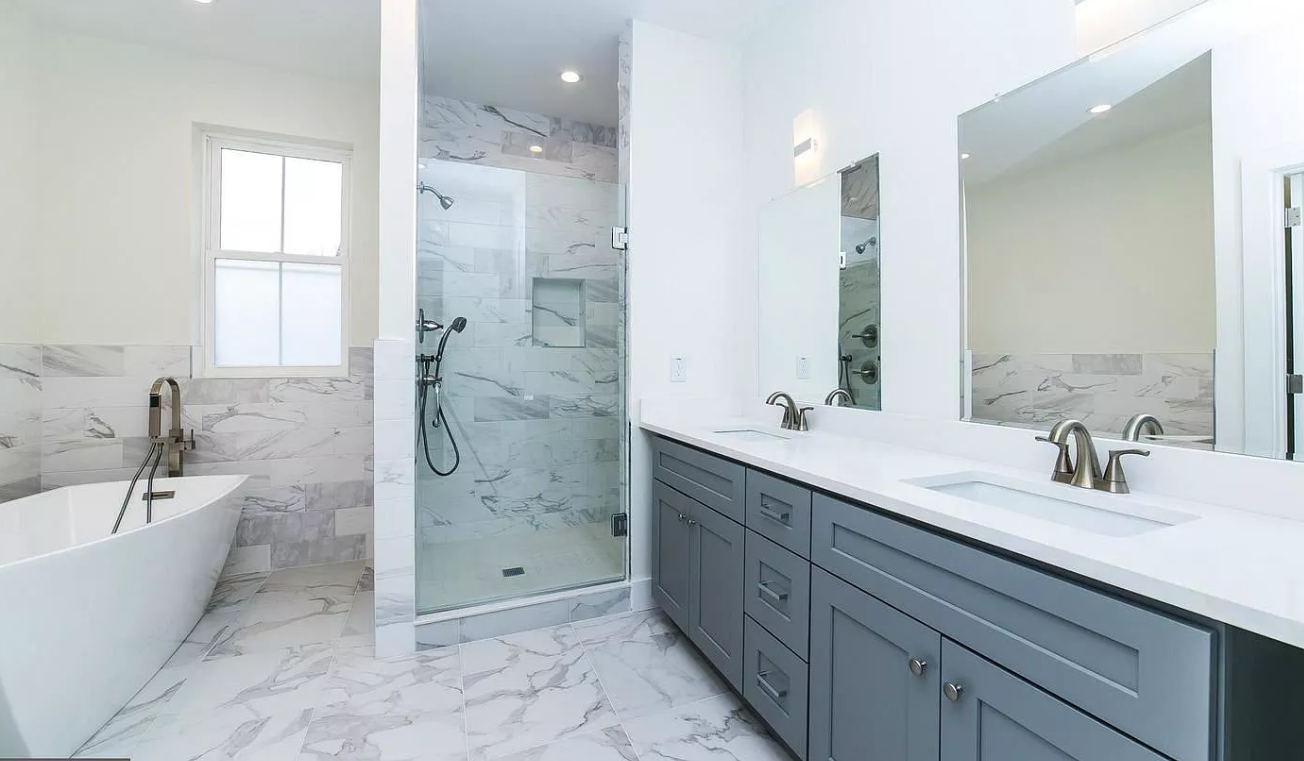 A bathroom with two sinks , a tub , and a walk in shower.