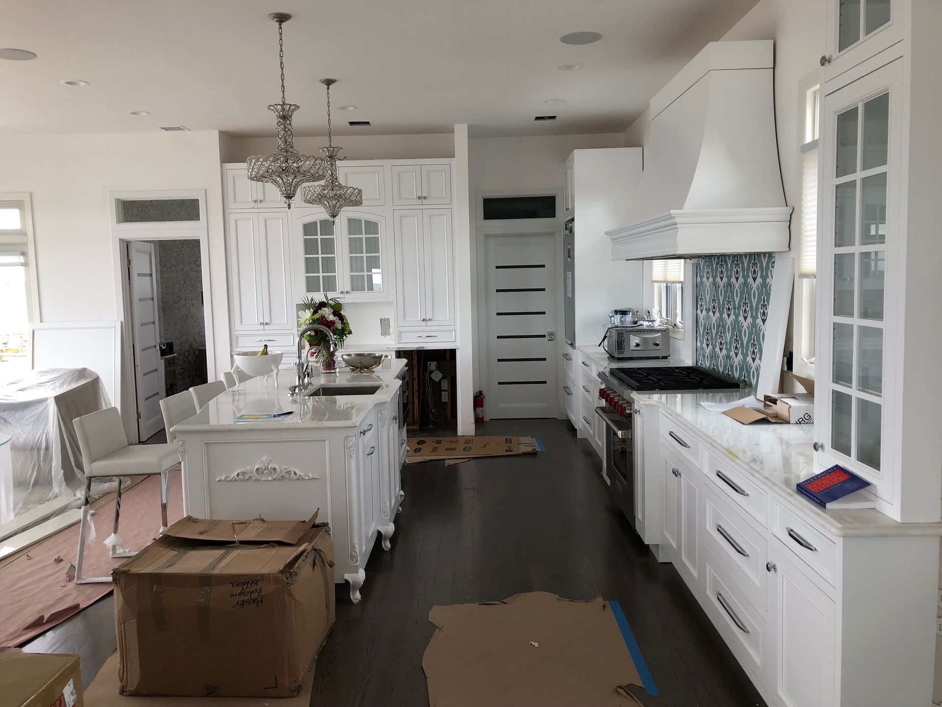 A kitchen with white cabinets and stainless steel appliances is being remodeled.