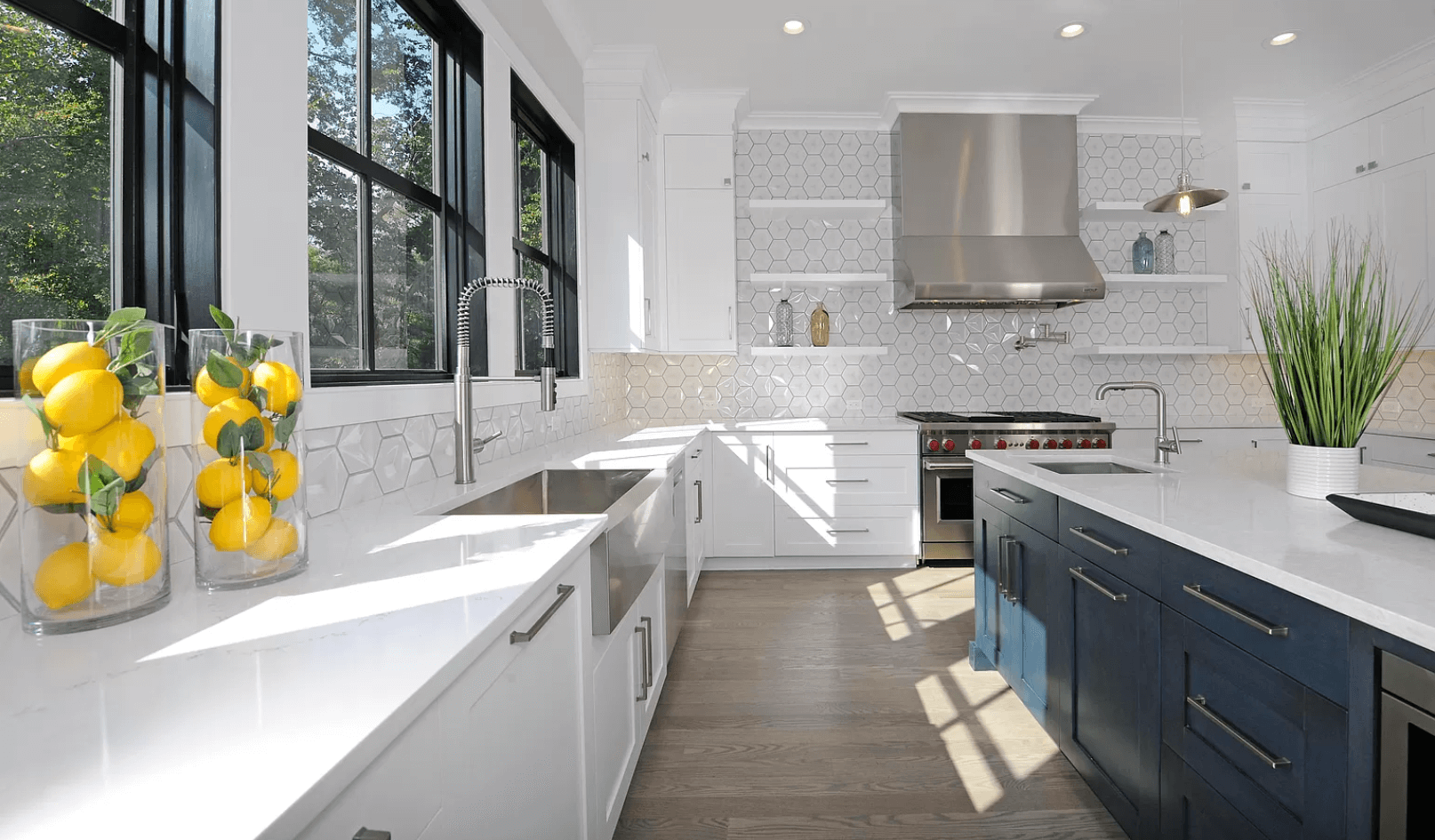A kitchen with white cabinets , stainless steel appliances , a sink , and a stove.
