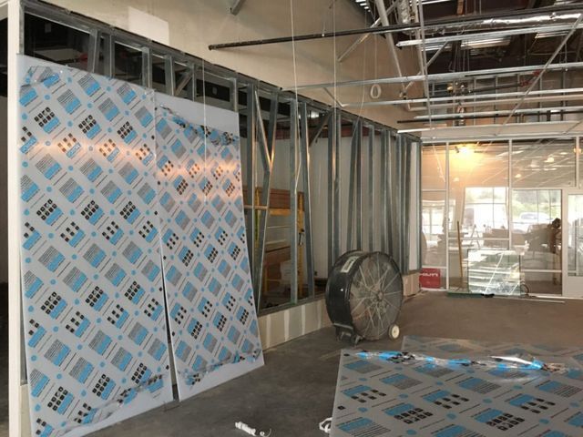 A room that is being remodeled with a fan on the floor
