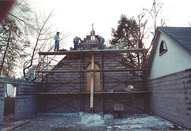 A group of people are working on a brick building