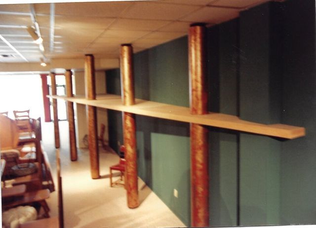 A room with a green wall and wooden shelves