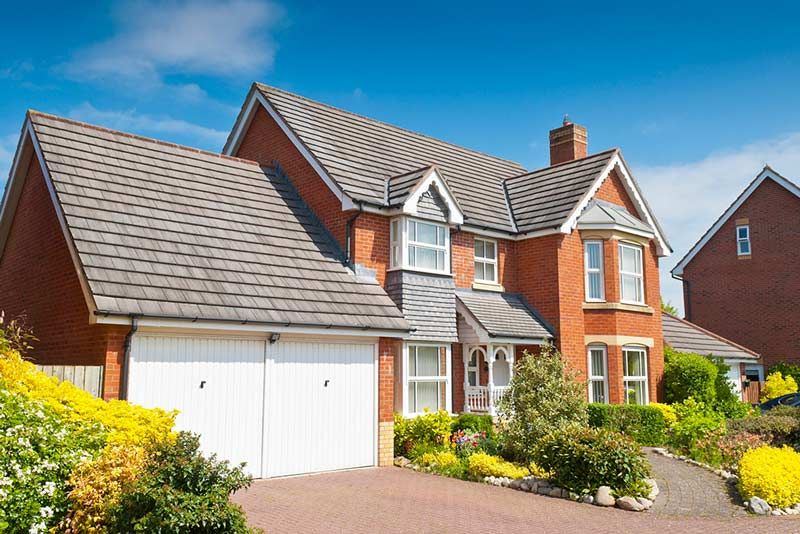 A large brick house with a garage and a driveway.