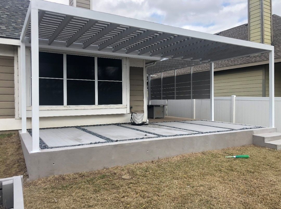 Covered front porch with metal framing and roof, adjacent to a house and grassy yard