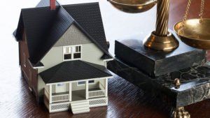 a small house next to scales of justice