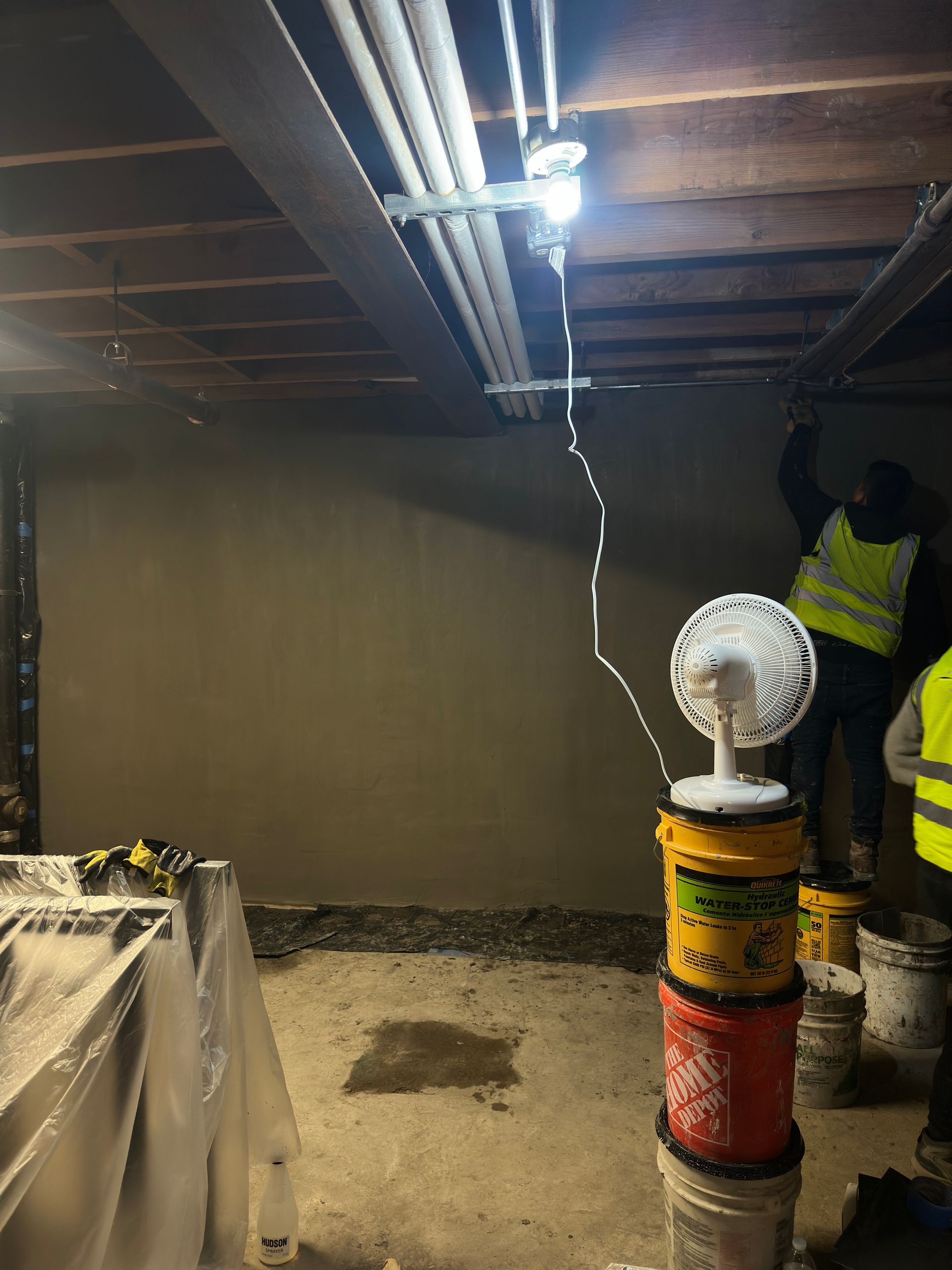 A group of construction workers are working in a basement