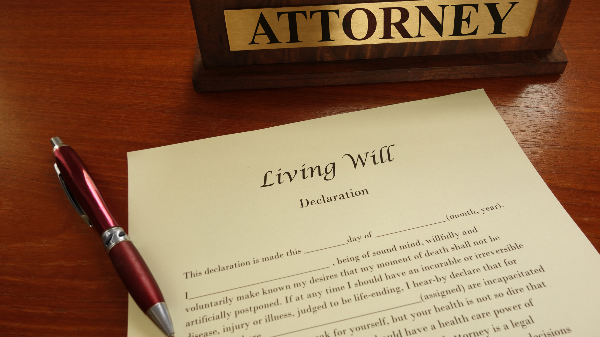 A living will is on a table next to an attorney sign