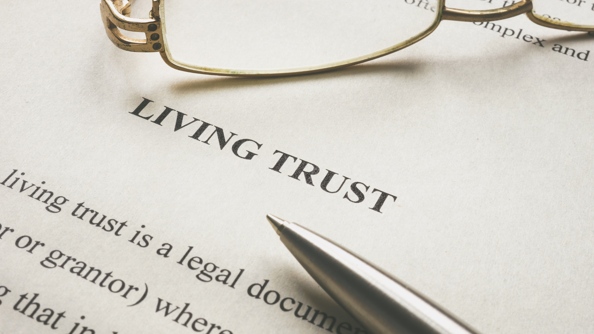 A pen is on a piece of paper that says living trust