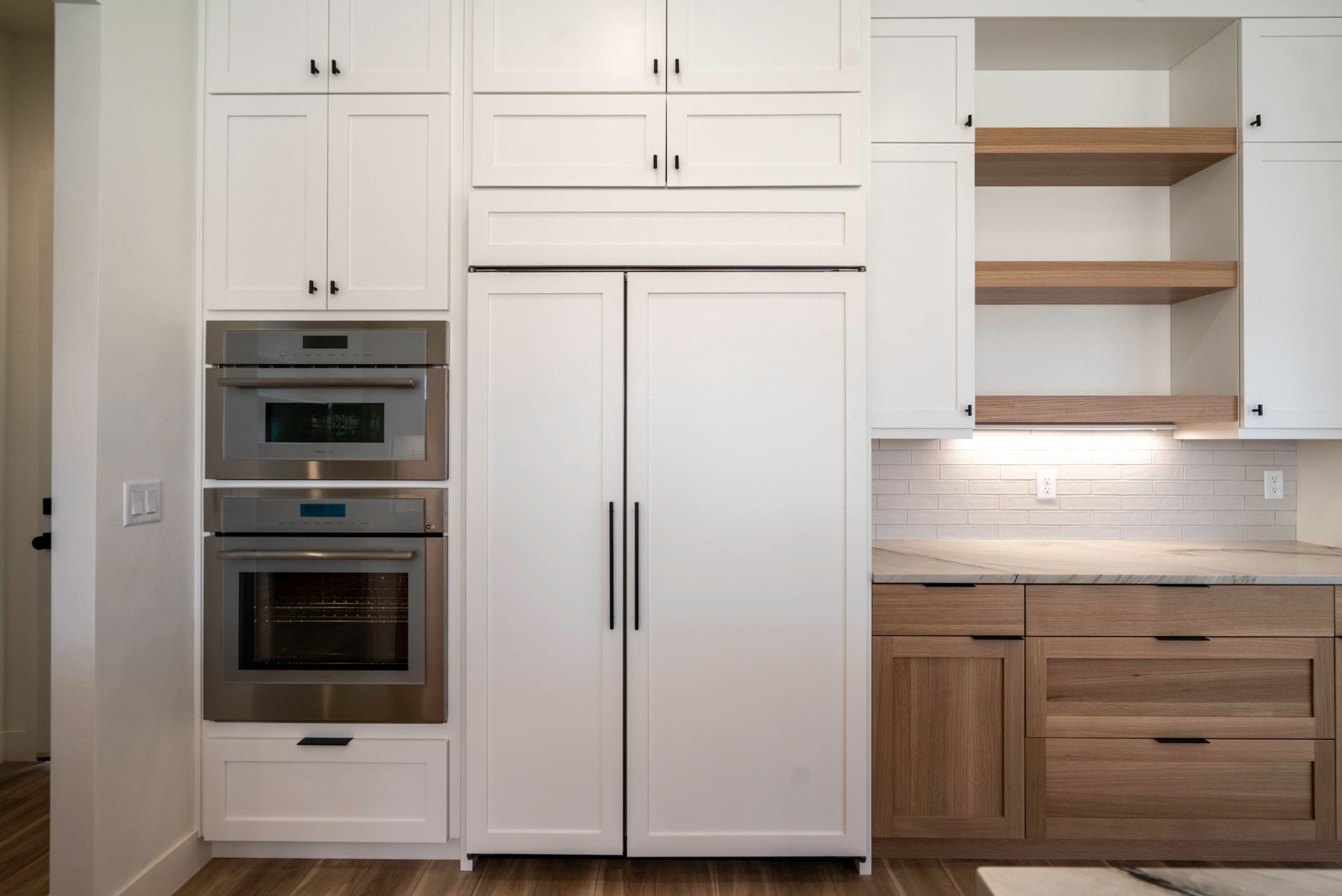 A kitchen with white cabinets , stainless steel appliances , and wooden cabinets.