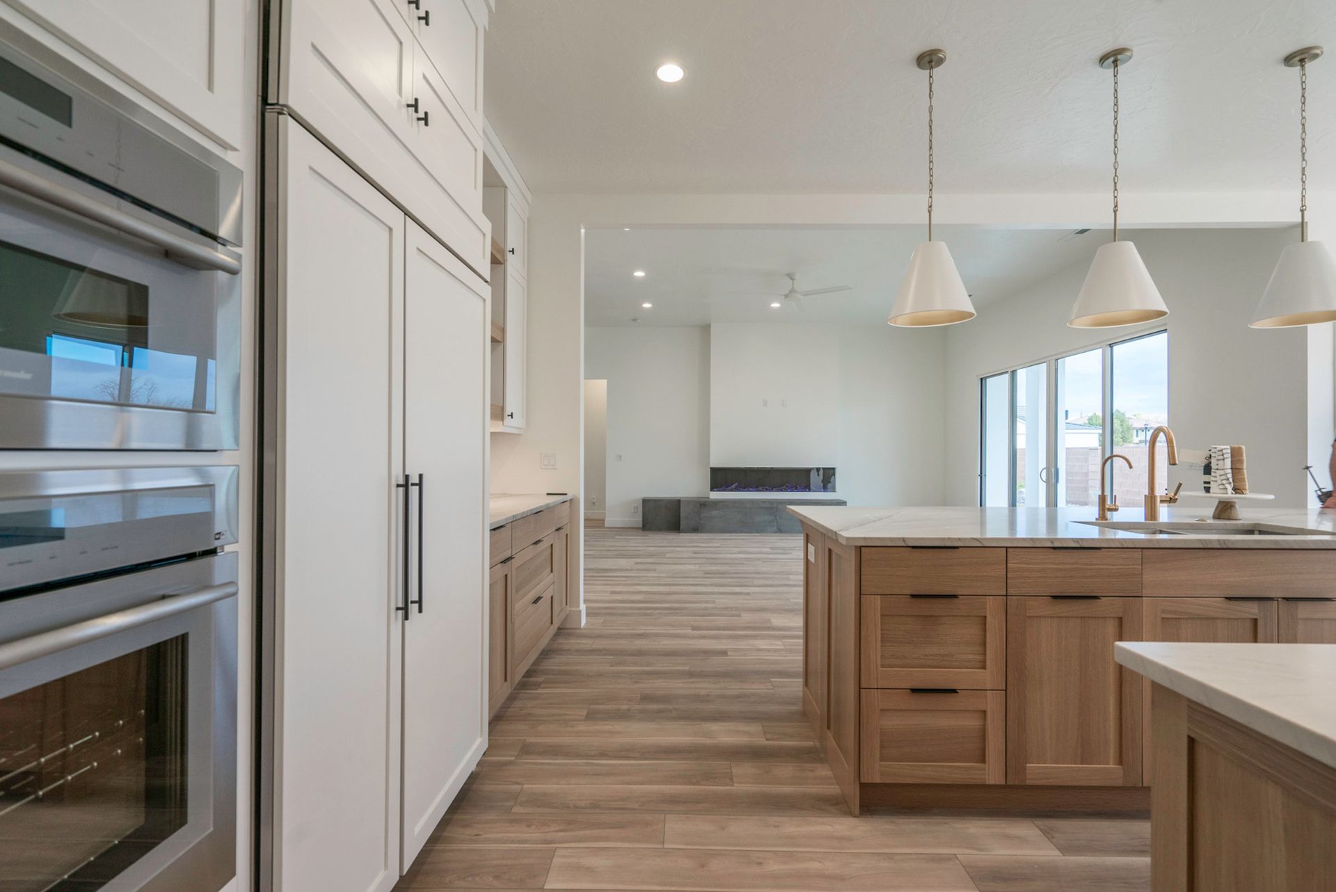 A kitchen with white cabinets , wooden cabinets , stainless steel appliances and a large island.