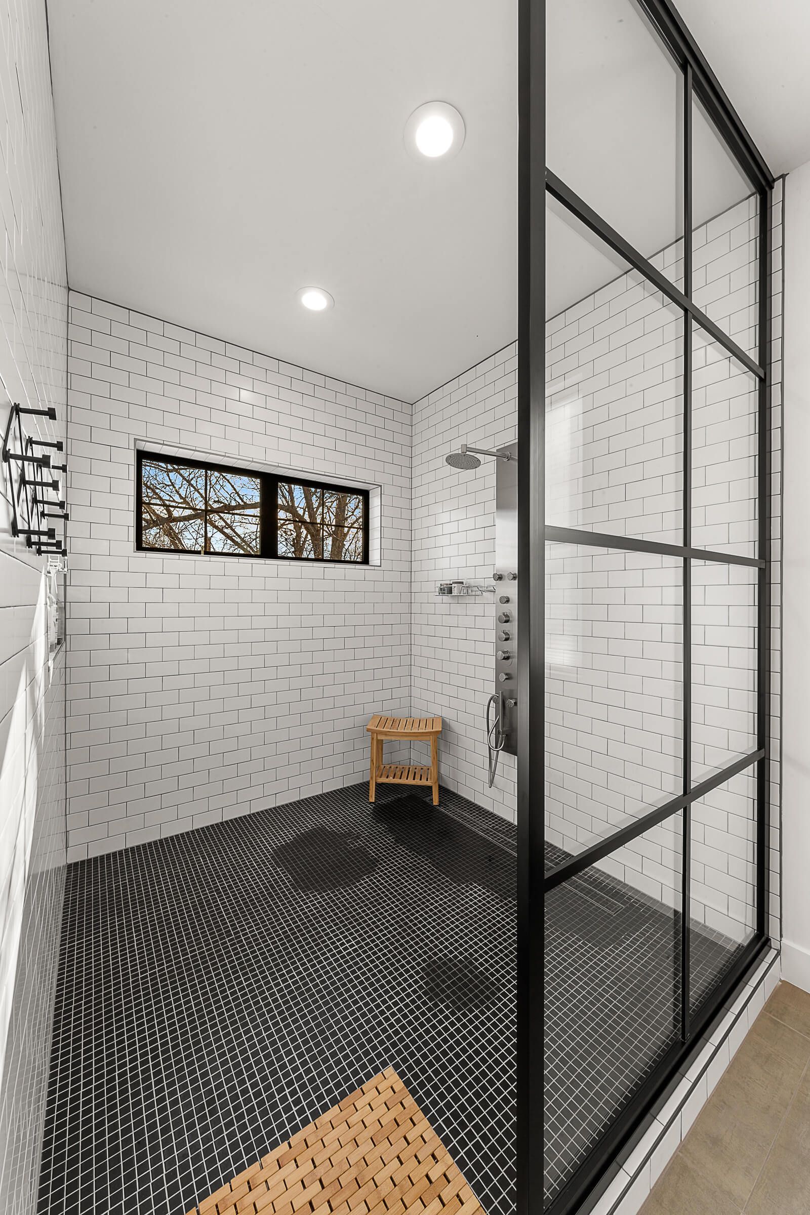 A bathroom with a walk in shower and a window.