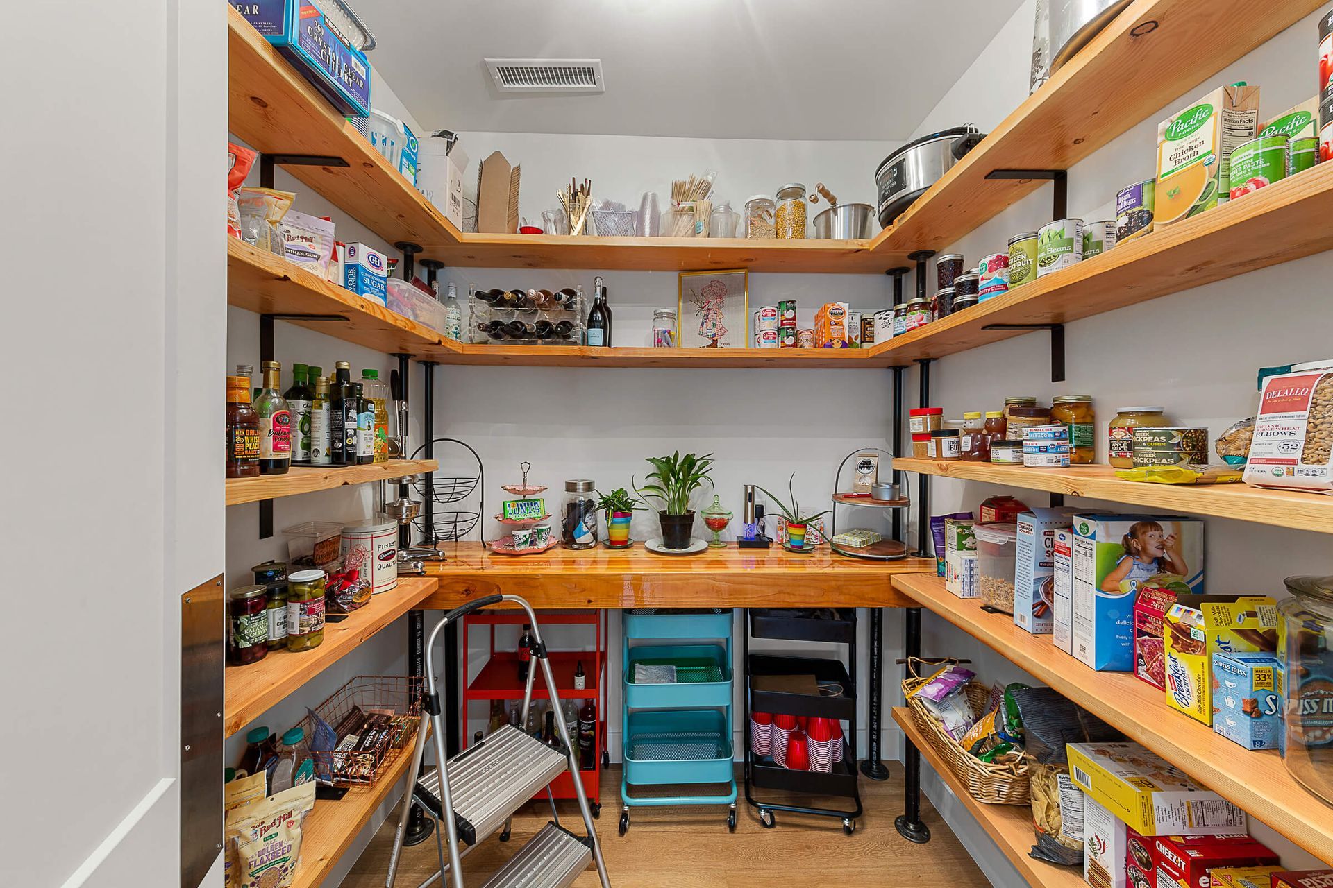 A pantry filled with lots of food and a ladder.