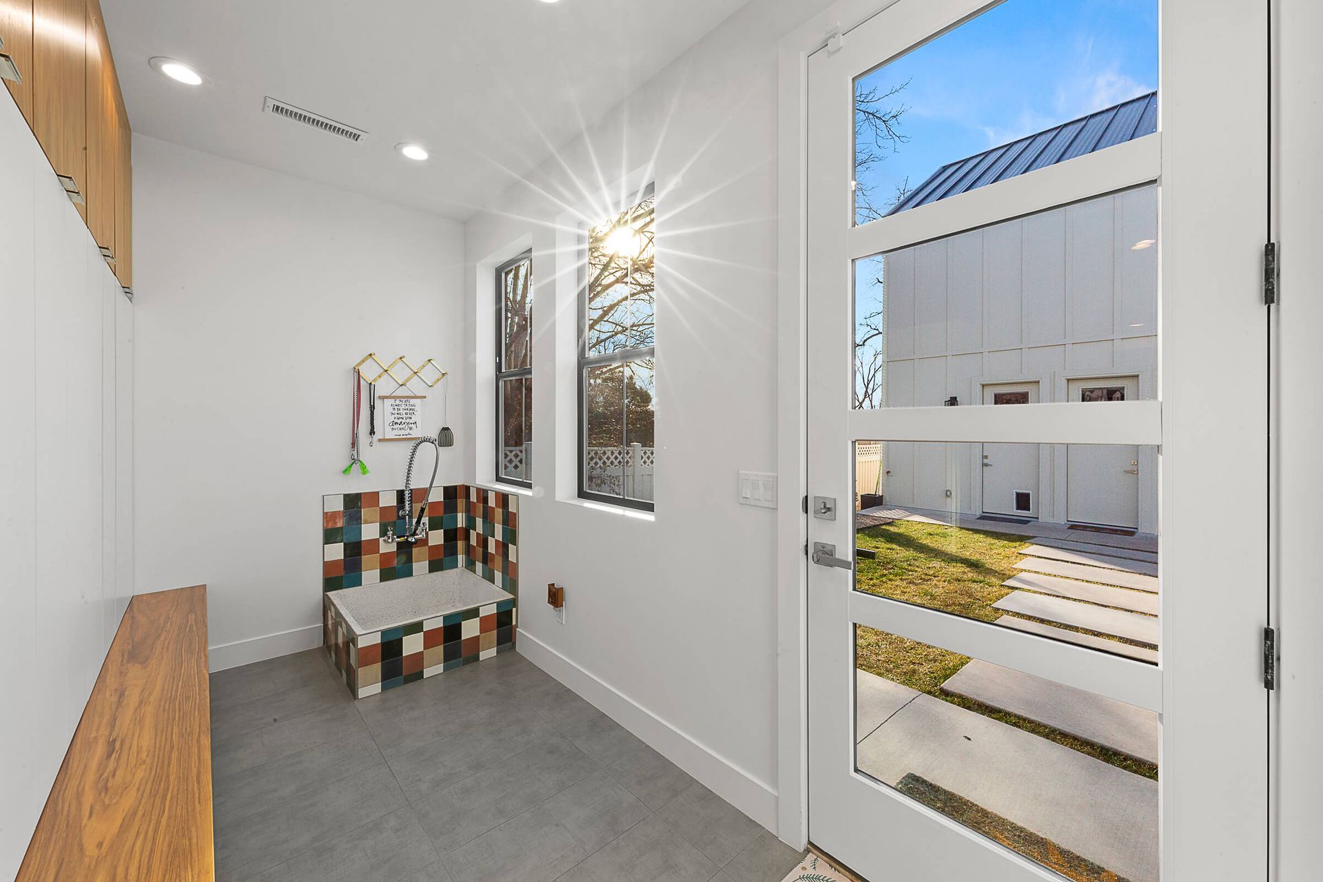 A hallway with a glass door and a bench.
