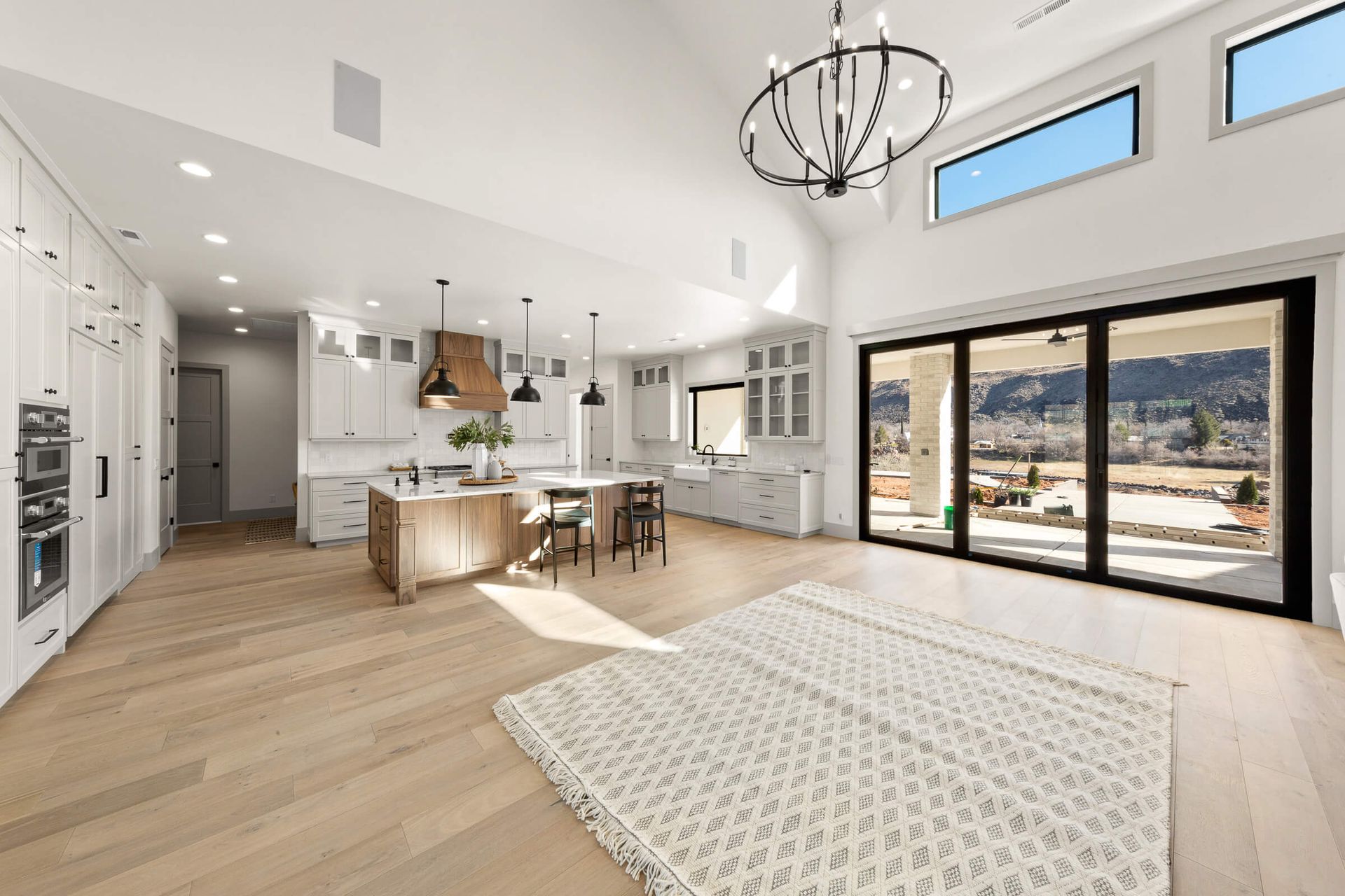 A living room and kitchen in a house with sliding glass doors.