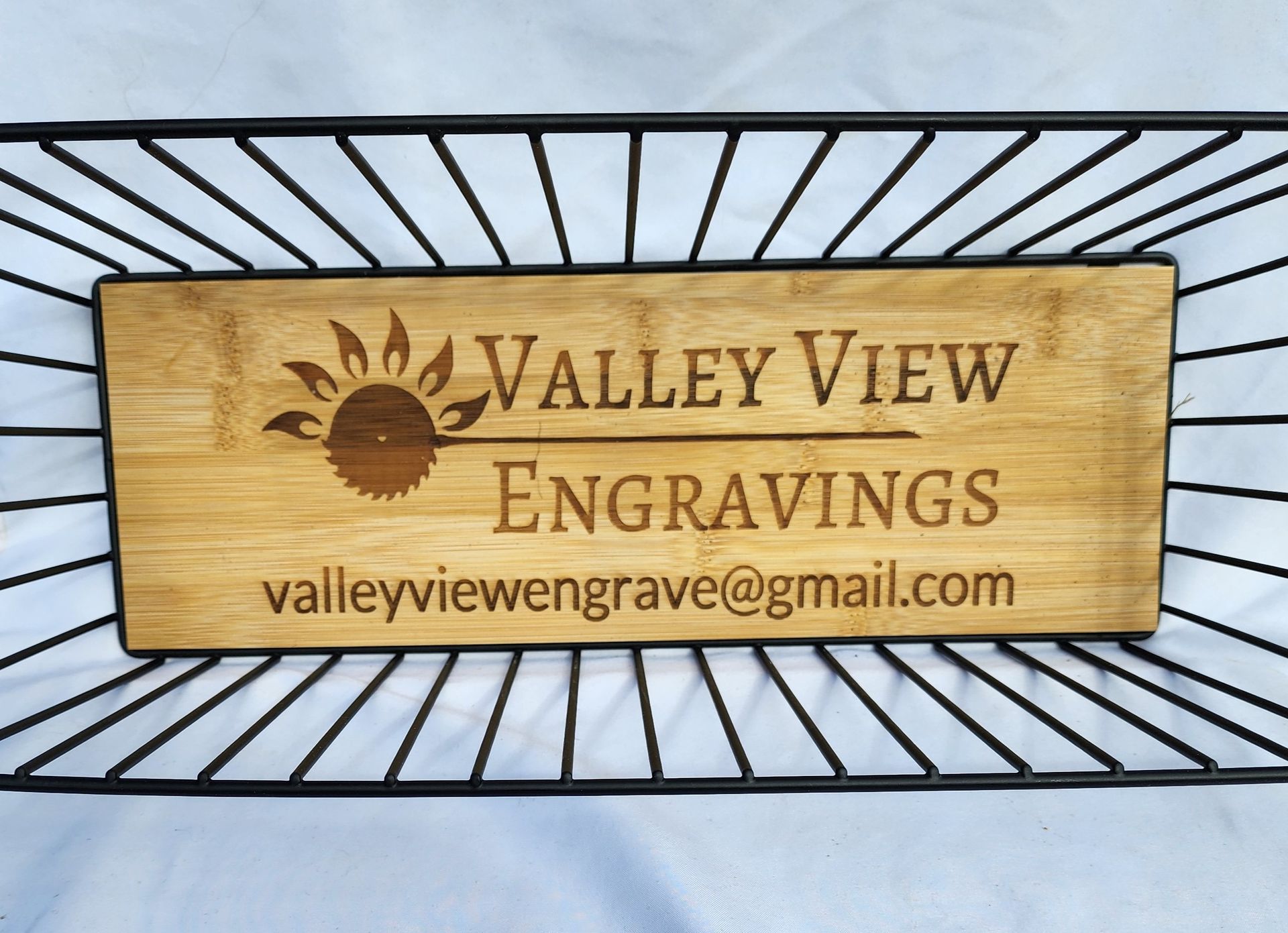 Wooden “Valley View Engravings” sign with email on a black metal background