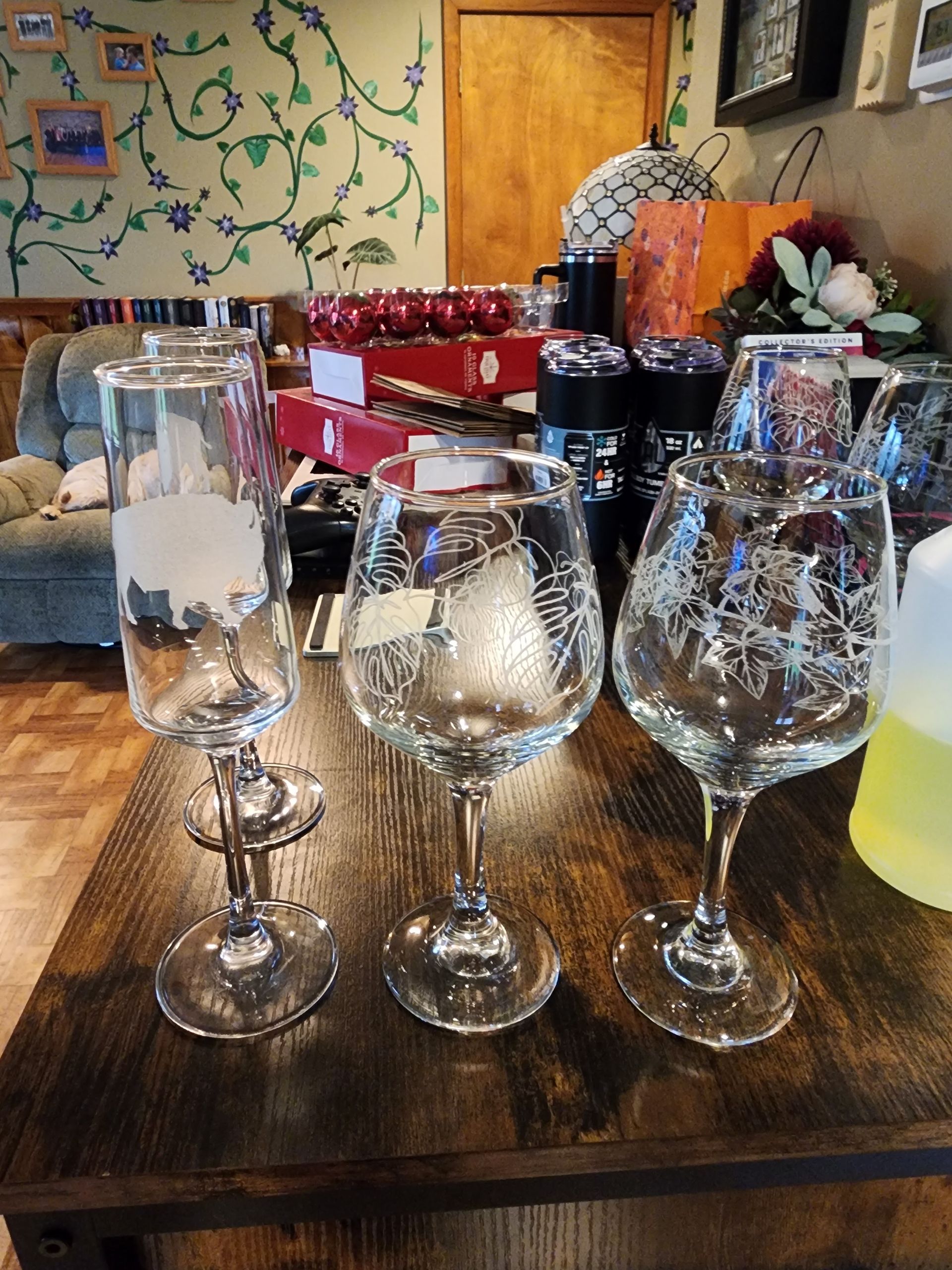 Glassware on a wooden table in a cozy indoor setting with holiday decor in the background