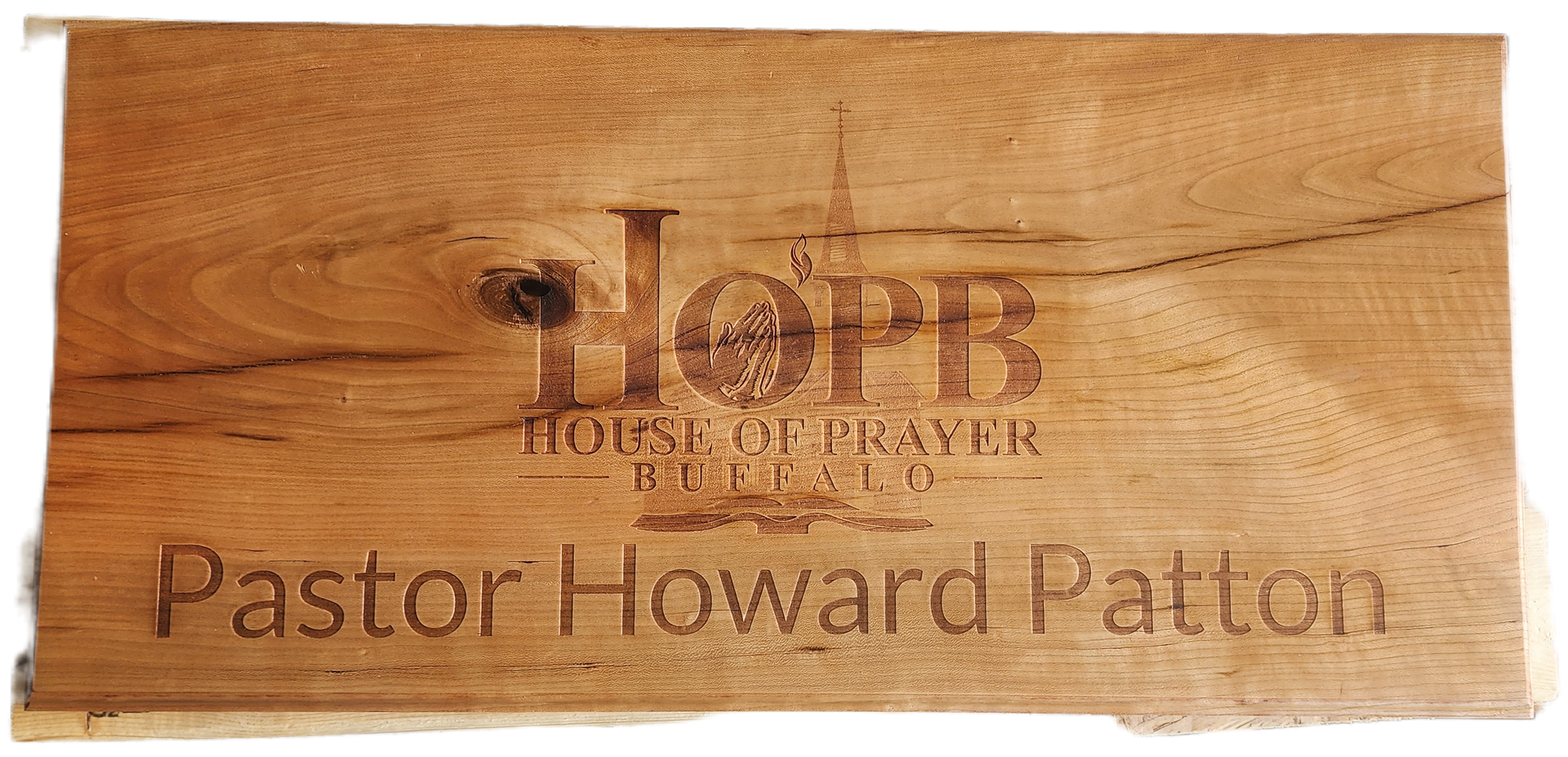 Wooden plaque engraved with “Hope House of Prayer” and “Pastor Howard Patton”