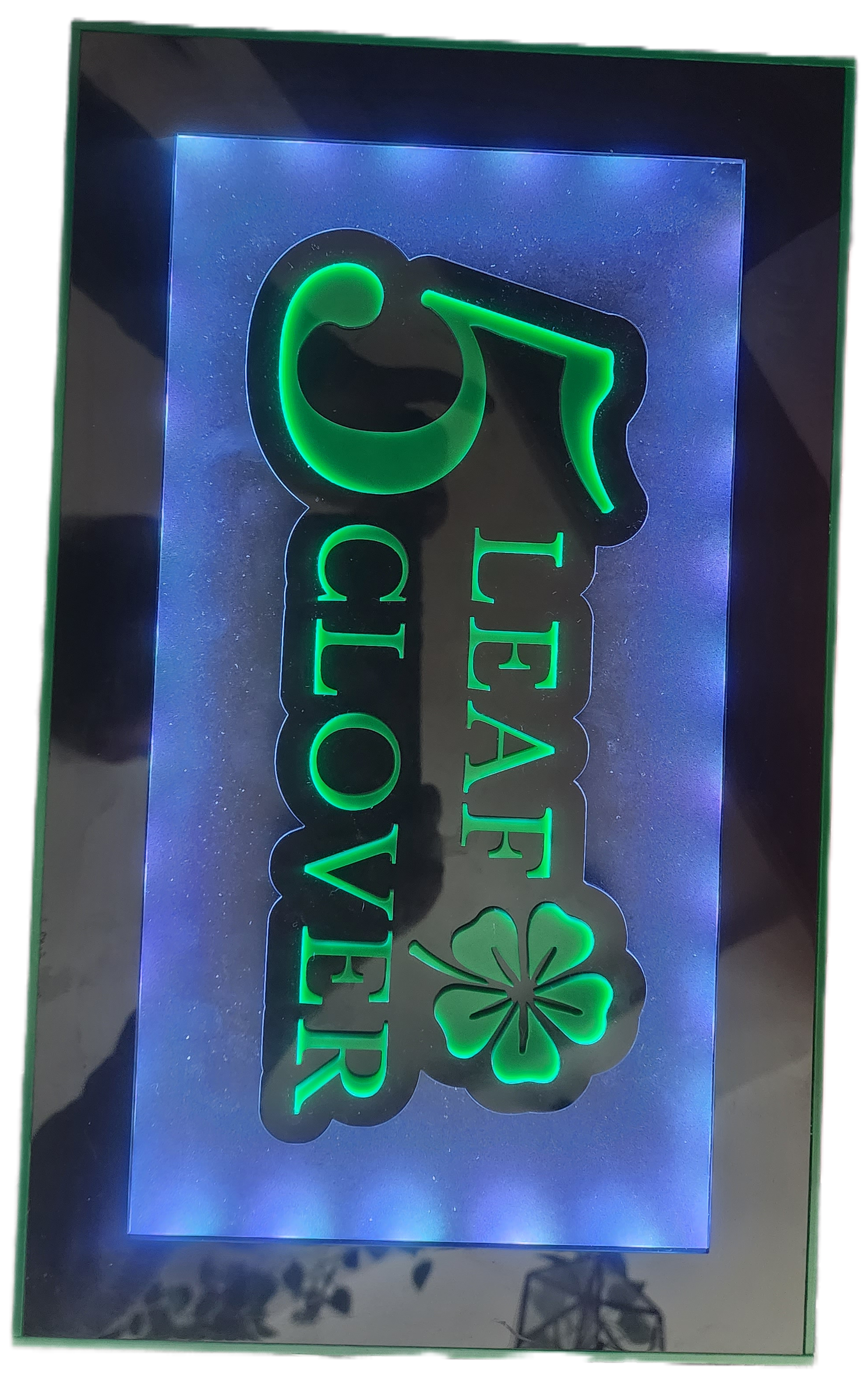 Neon green “Leaf Clover” sign on a dark background with a purple glow