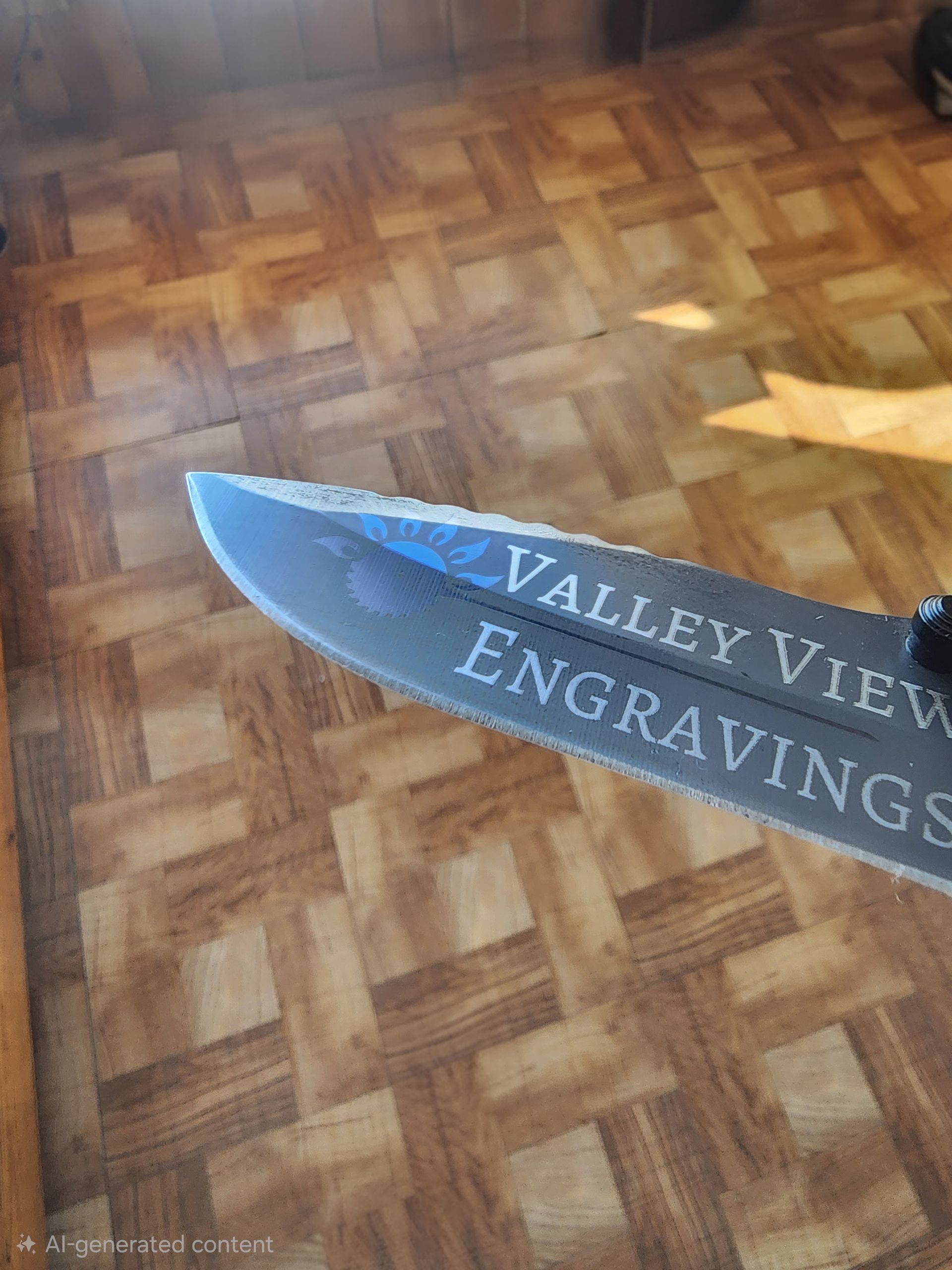Blue engraved knife on wood floor, labeled “VALLEY VIEW ENGRAVINGS”
