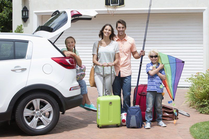 Portrait of smiling family packing car — Illawarra Car Service Centre In Oak Flats NSW