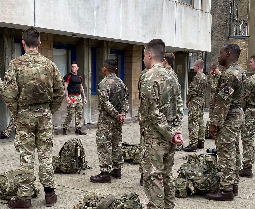 A group of soldiers are standing in front of a building.