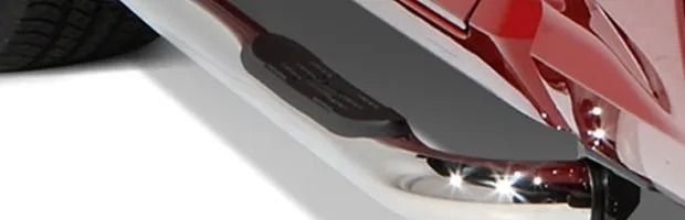 Close-up of a red scooter’s rear wheel and black footrest on a white background