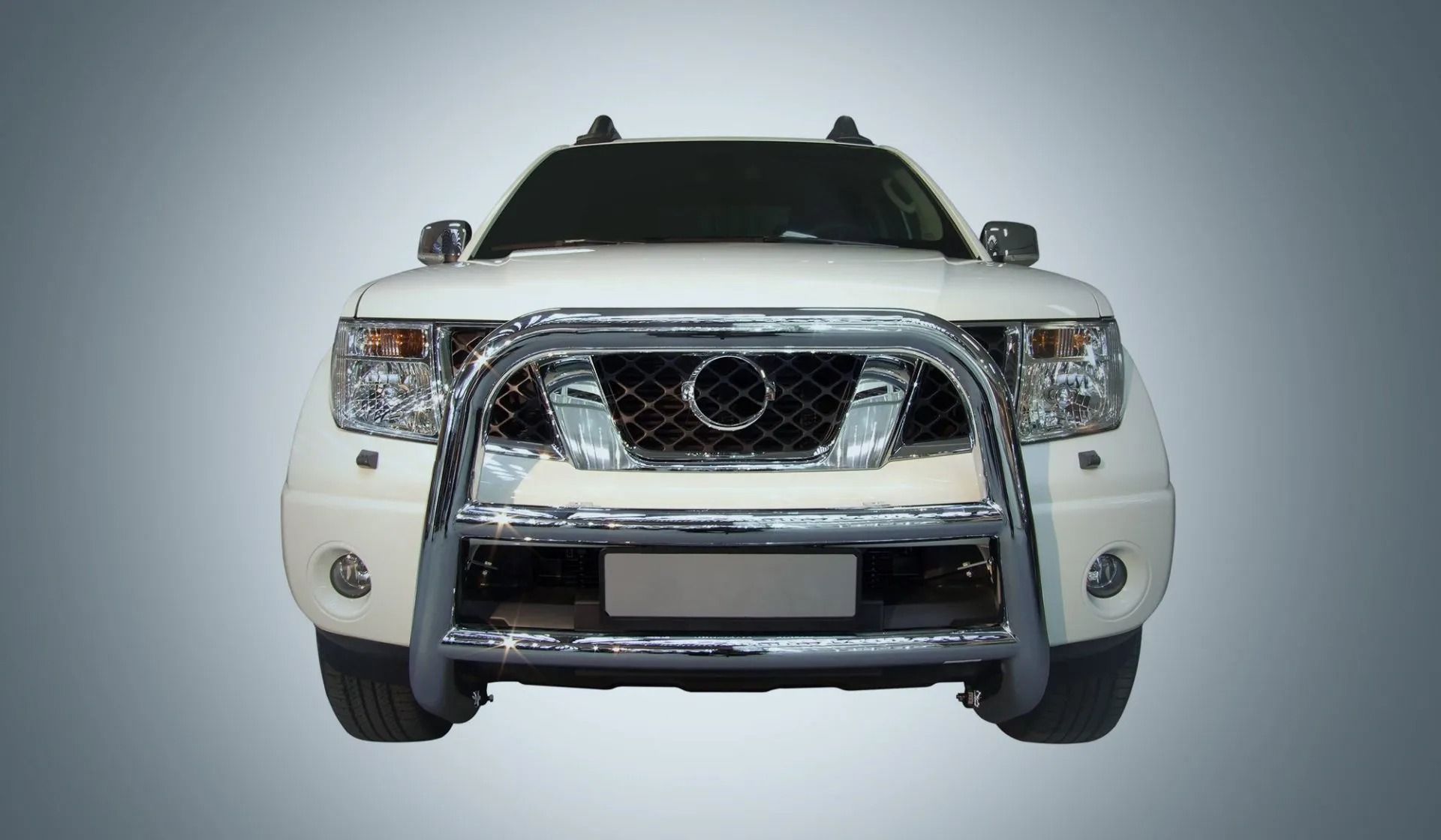Front view of a white SUV with a chrome grille on a plain gray background
