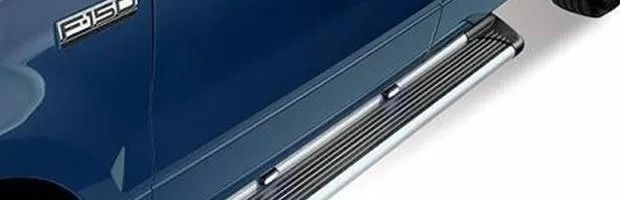 Blue car side panel with chrome running board and badge emblem