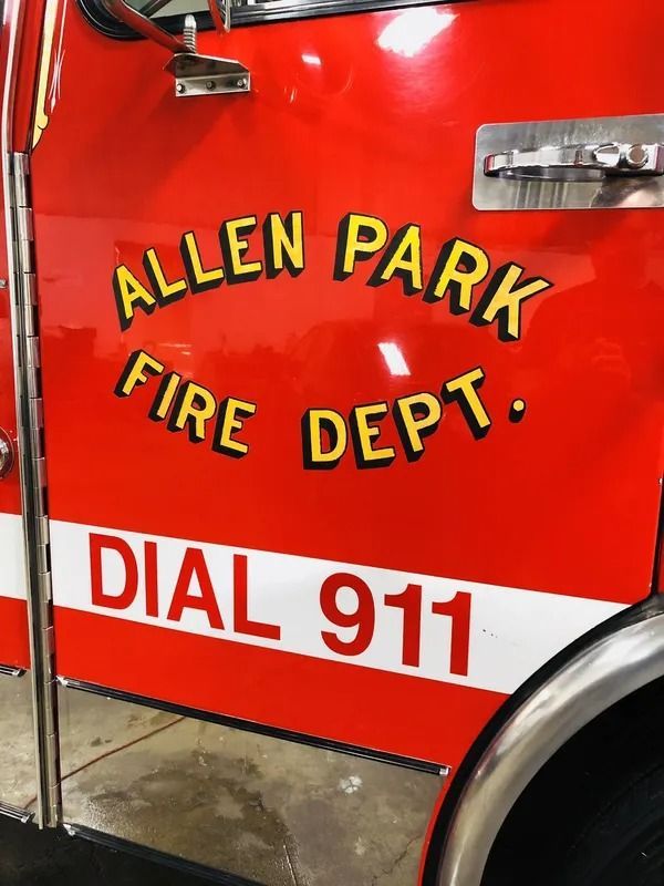 Red fire truck door labeled “Allen Park Fire Dept.” with “DIAL 911” on the side.