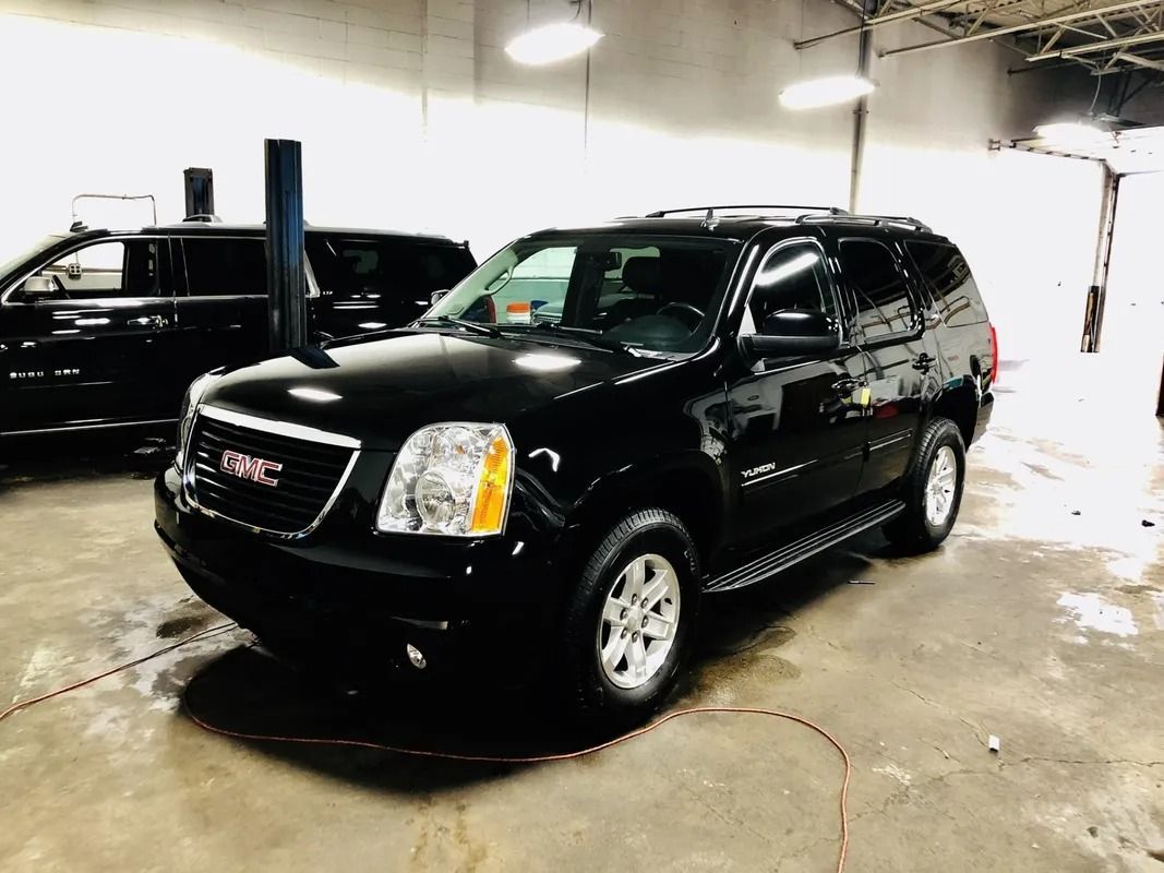 Black GMC SUV parked indoors in a bright garage