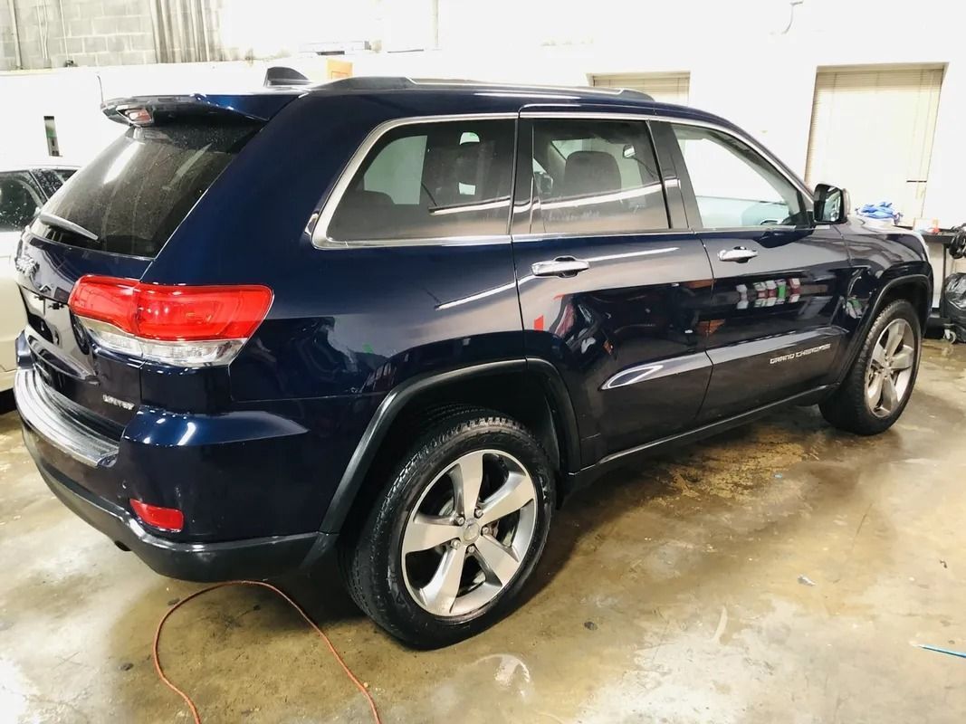 Dark blue SUV parked indoors in a garage, rear three-quarter view
