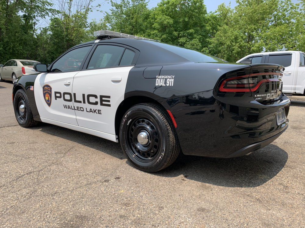 Black-and-white police cruiser parked outdoors on a sunny day