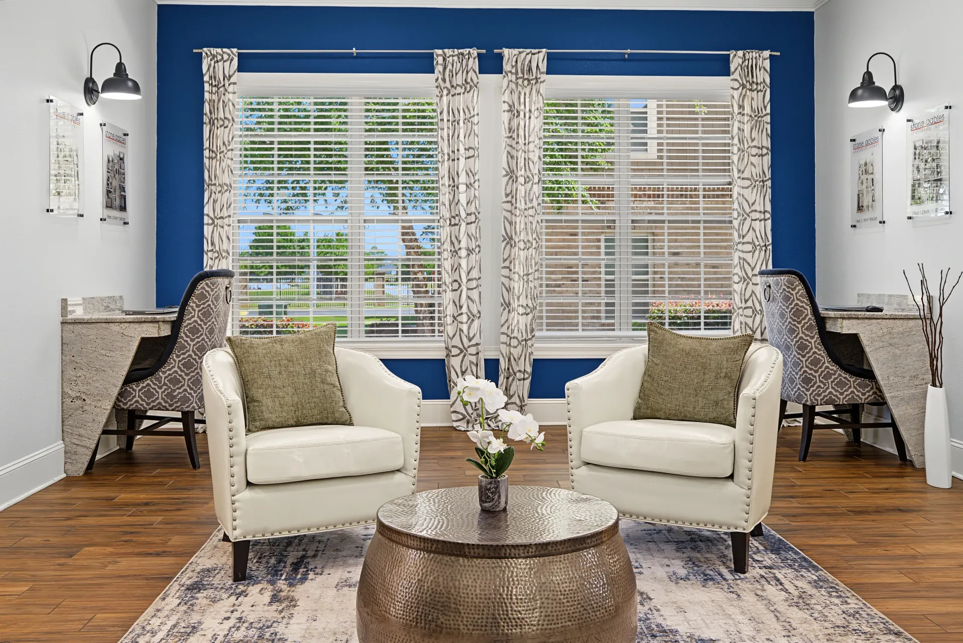 Comfortable seating area with two armchairs, a coffee table, and two workstations with chairs.
