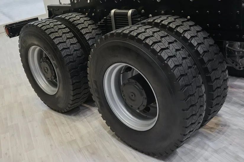 Four Black Truck Tires With Gray Rims on a Light-colored Floor — Wheel Alignment Centre in Braitling, NT