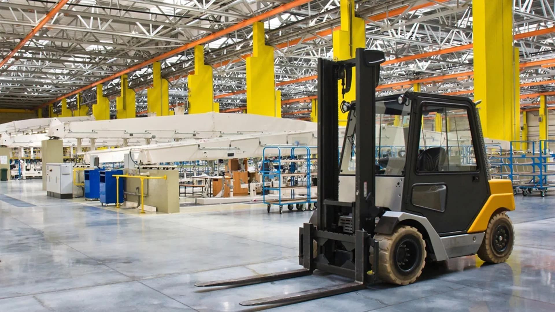 Forklift in a Factory Setting With Yellow Support Beams and Machinery — Wheel Alignment Centre in Braitling, NT