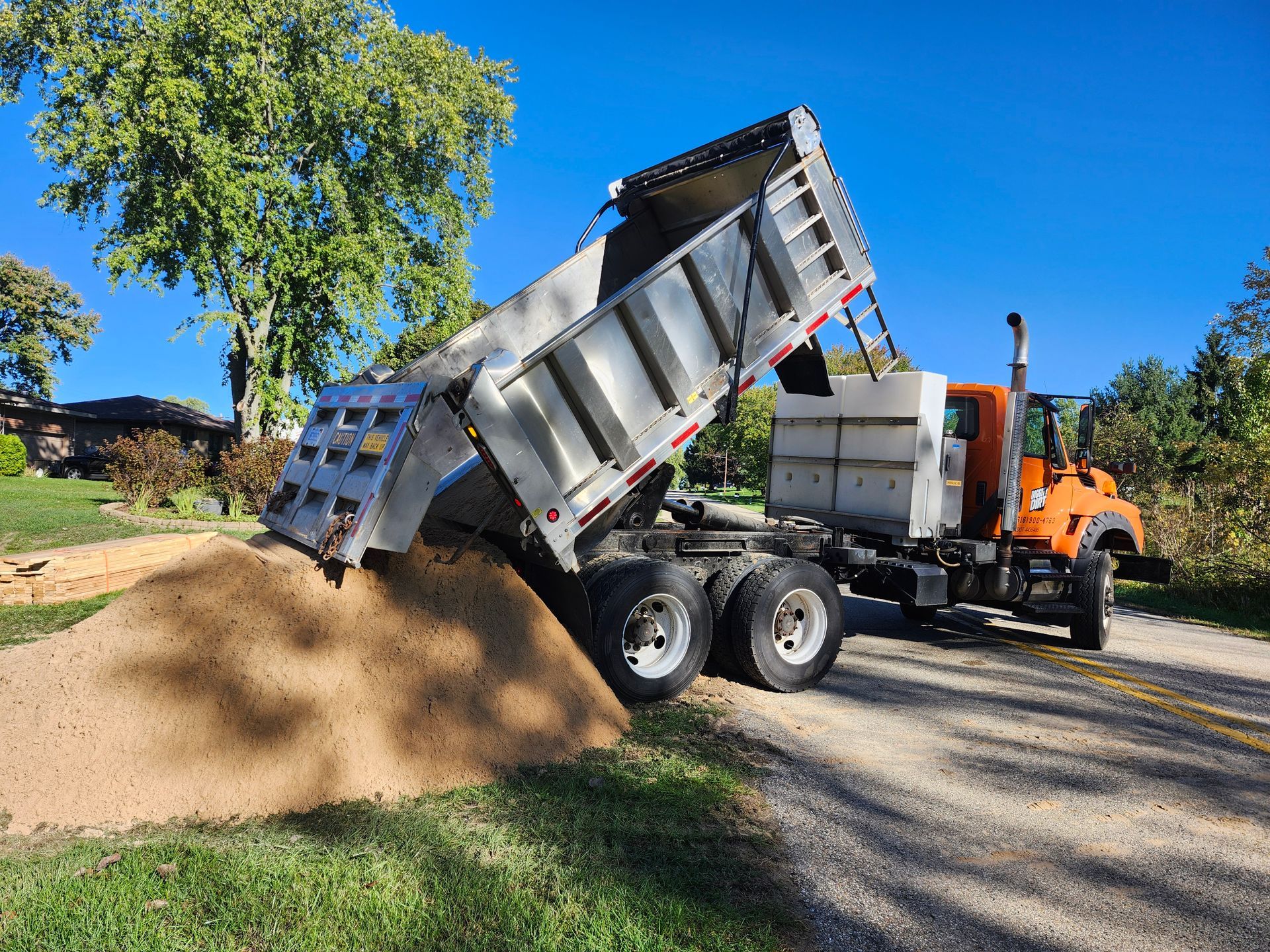 A man is working on a bulldozer on a dirt road.
