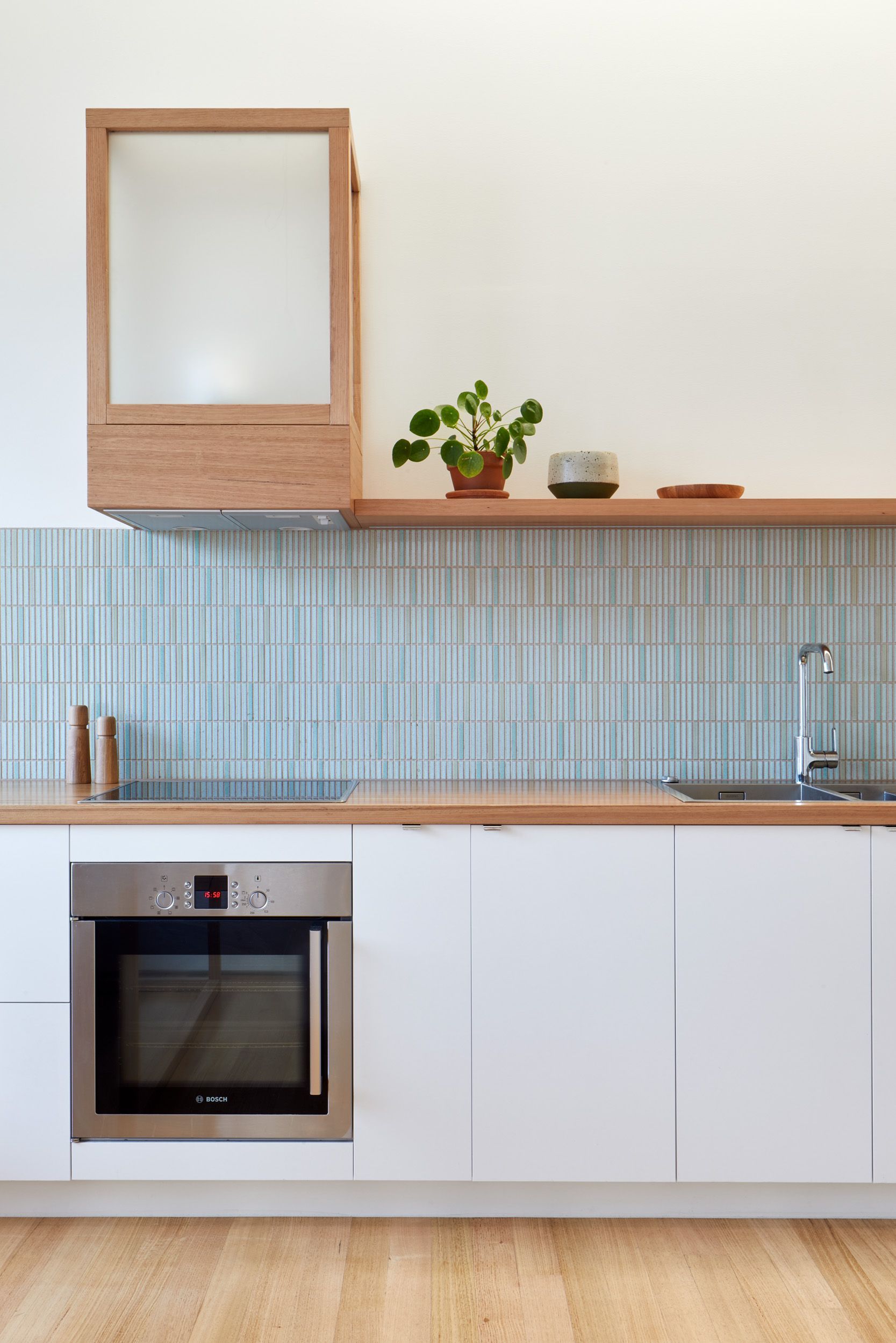 A kitchen with white cabinets and a stainless steel oven