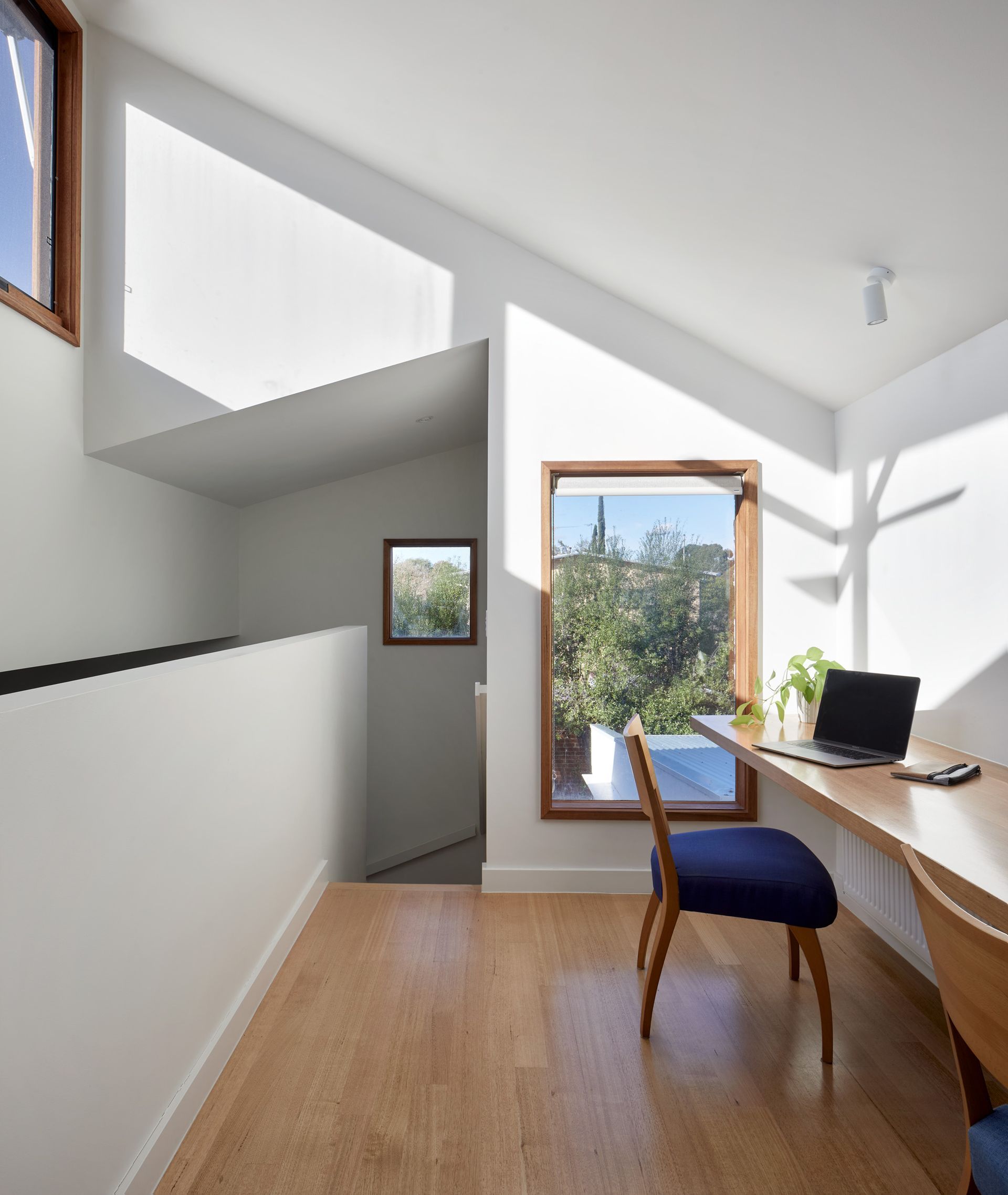 A room with a desk and chair with a laptop on it