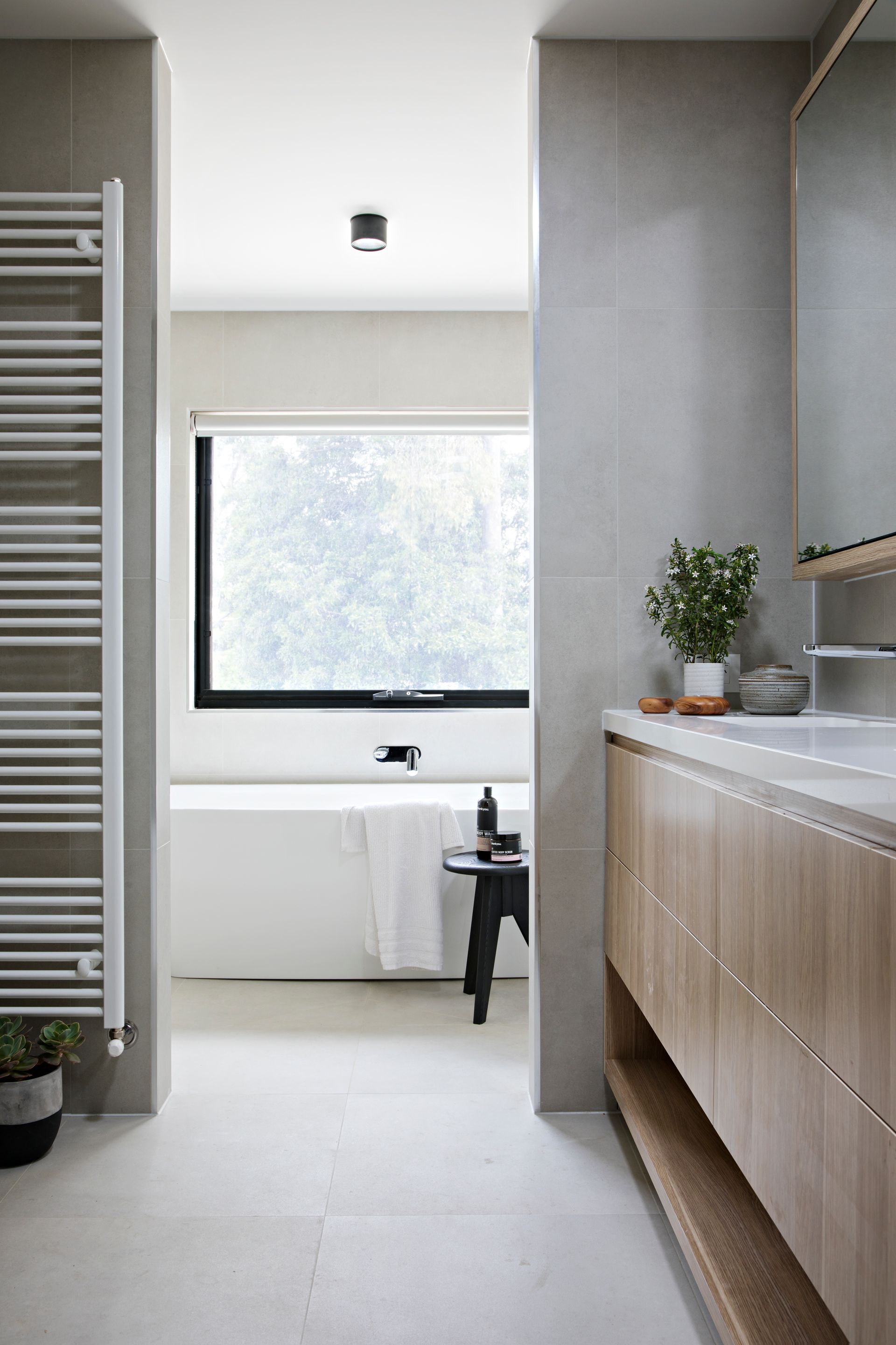 A bathroom with a bathtub , sink , and towel rack.