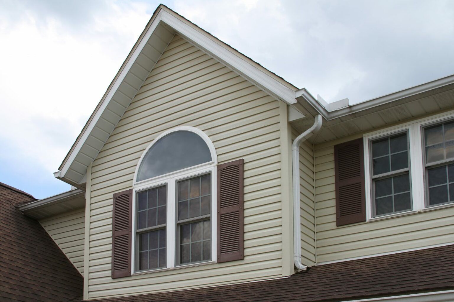 A roof with a green gutter and trees in the background