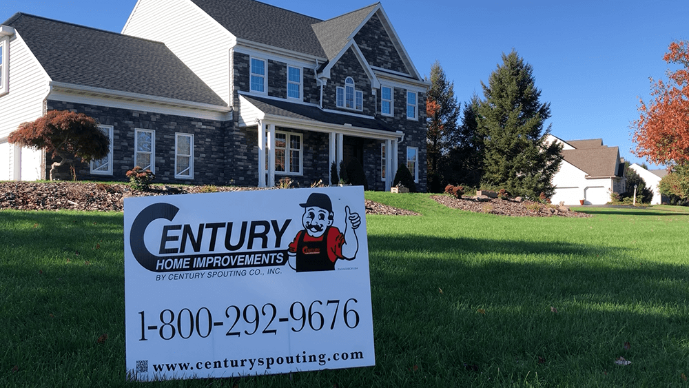 Sign for Century Home Improvements in front of a house. Contact info and logo included.