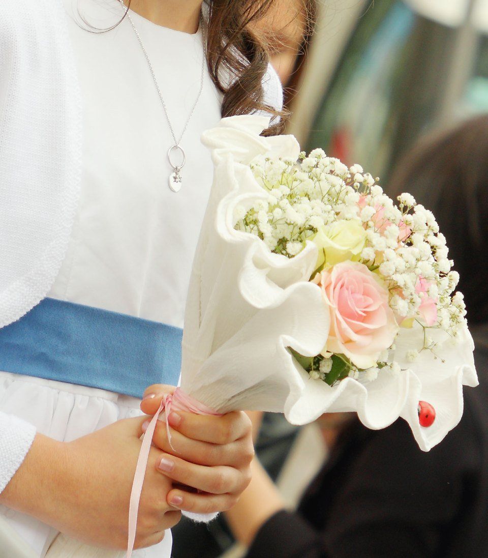 Bambina con bouquet di fiori bianco e rosa in mano