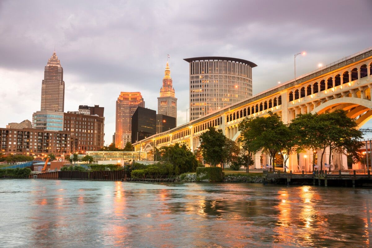 A bridge over a body of water with a city skyline in the background.