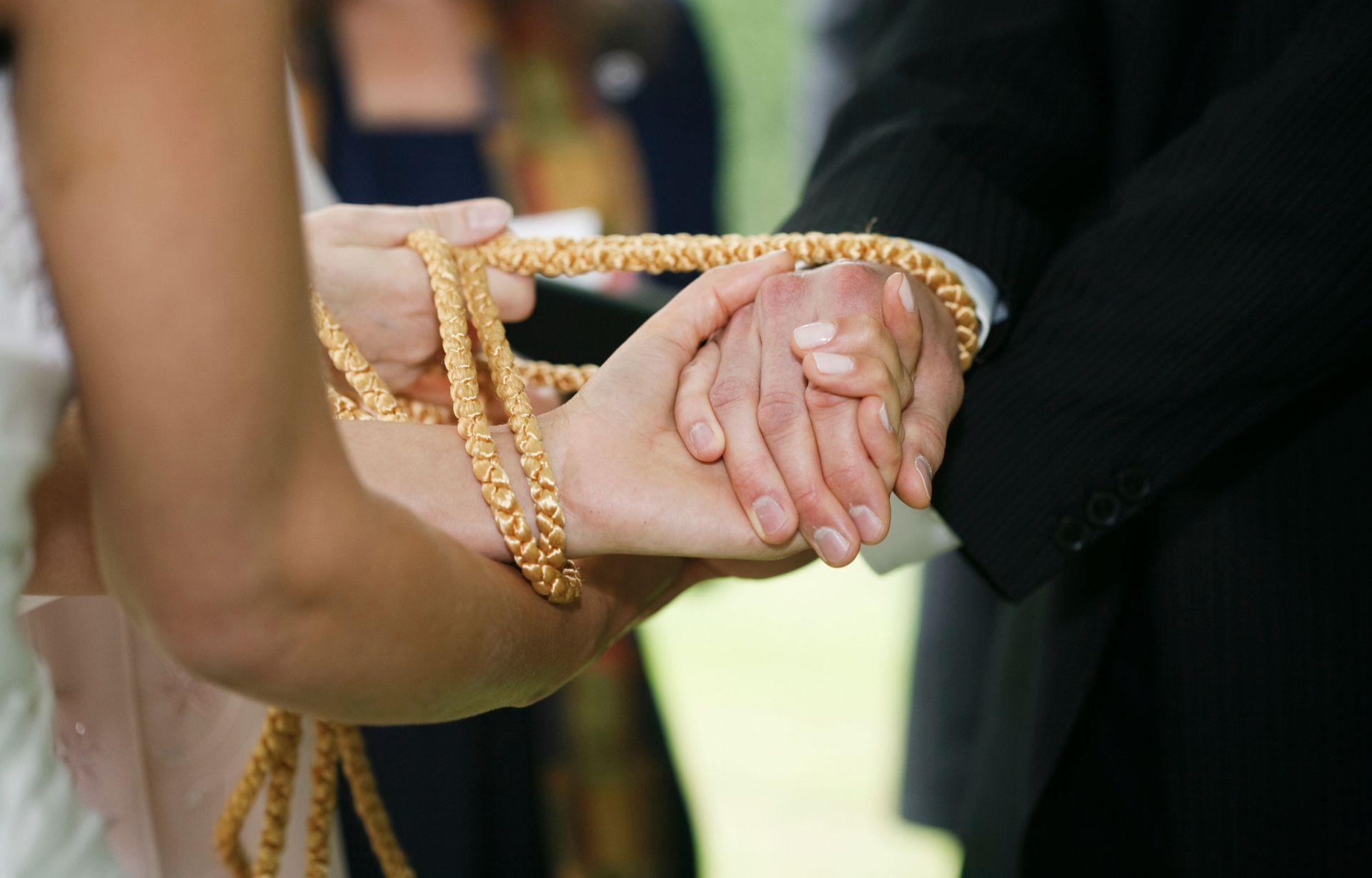 A bride and groom are tied together with a rope during their wedding ceremony.