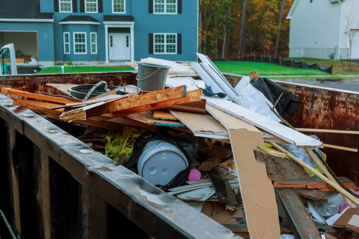 a dumpster filled with wood, cardboard, and various plastics