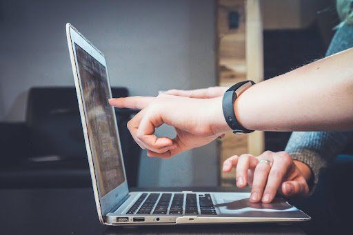 People pointing at laptop