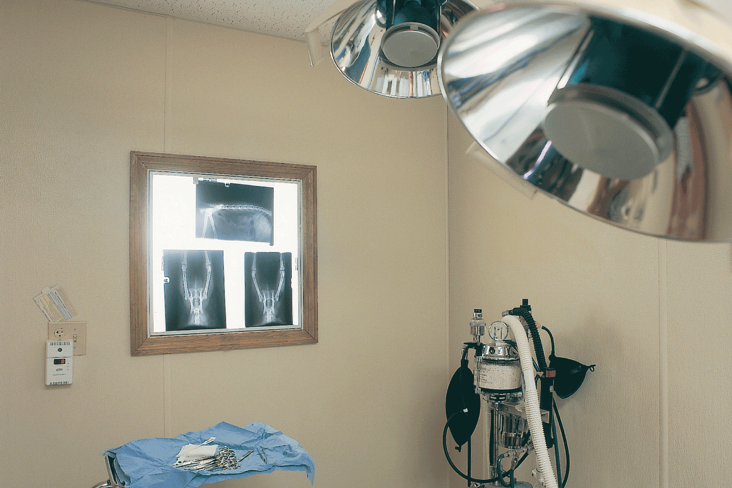 An operating room with a mirror and x-rays on the wall