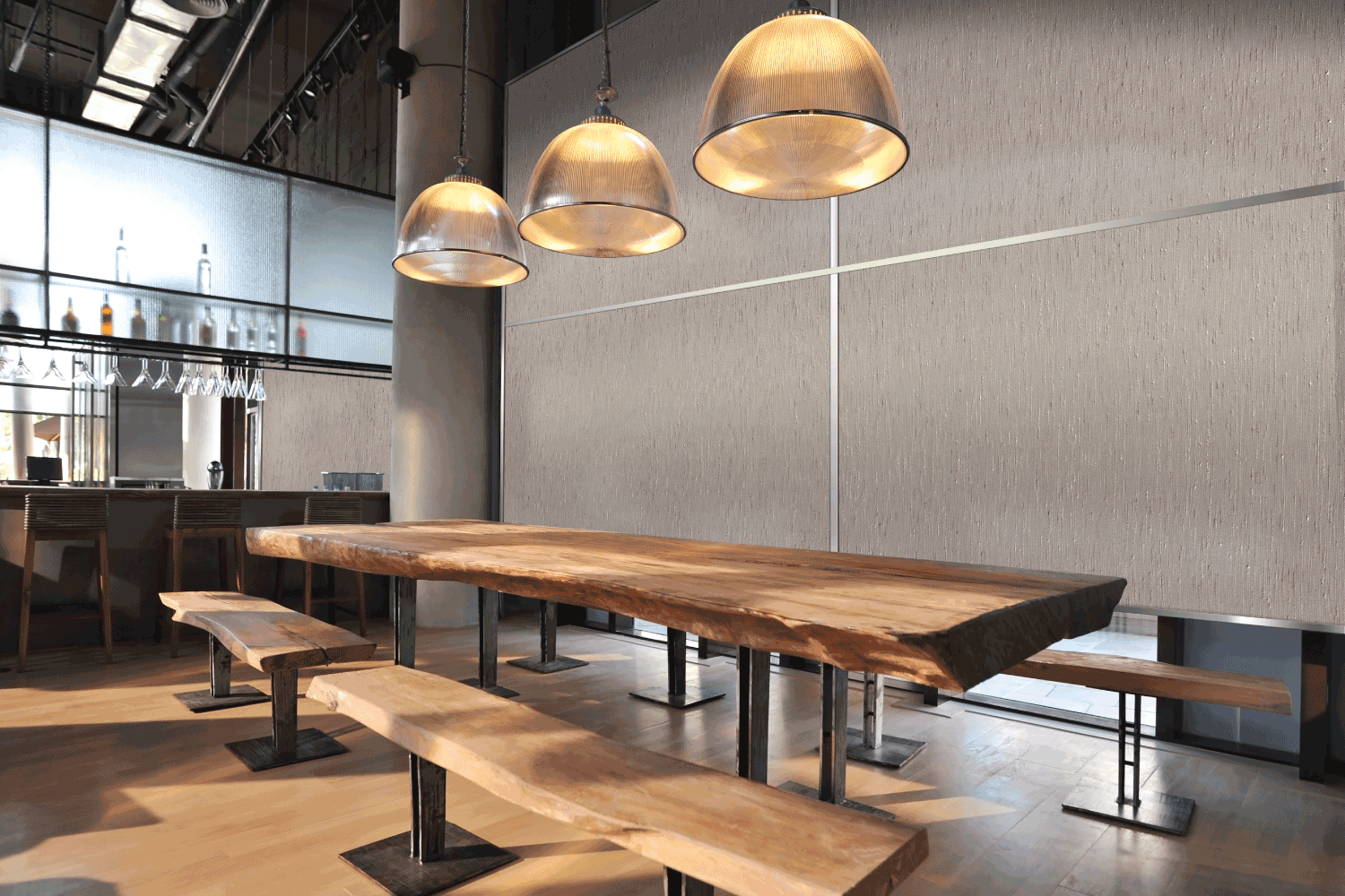 A restaurant with a long wooden table and benches.